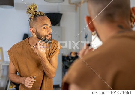 Black male gay applying make up 101021661