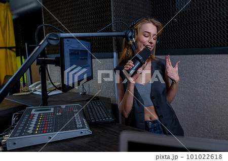 Young female singer singing at the record studio 101022618