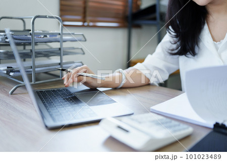 financial, Planning, Marketing and Accounting, portrait of Asian employee checking financial statements using documents, calculators and computer laptop at work. financial, Planning, Marketing and Accounting, portrait of Asian employee checking financial statements using documents, calculators and computer laptop at work. 101023489