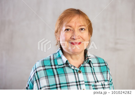 Smiling elderly woman in plaid shirt looking at camera 101024282