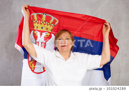 Cheerful senior woman standing confidently with serbian flag Cheerful senior woman standing confidently with serbian flag 101024289