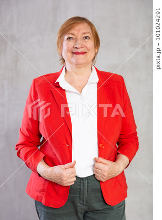 Happy mature lady standing with confident radiant smile Happy mature lady standing with confident radiant smile 101024291
