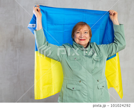 Cheerful elderly woman holding national flag of Ukraine Cheerful elderly woman holding national flag of Ukraine 101024292