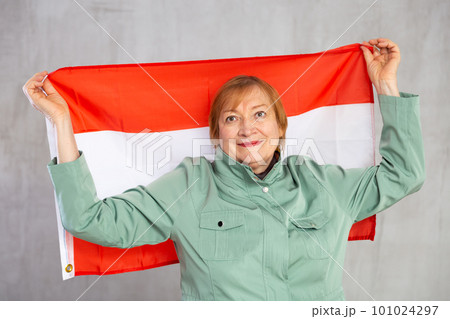 Cheerful senior woman standing confidently with austrian flag 101024297