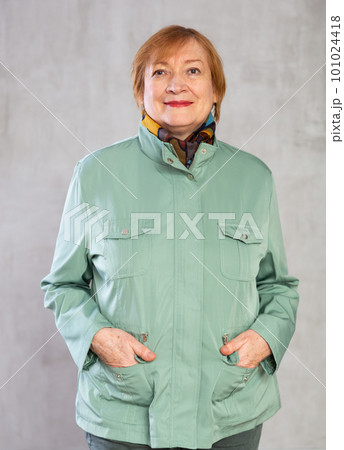 Senior woman standing confidently dressed in warm clothes with smile full of cheer Senior woman standing confidently dressed in warm clothes with smile full of cheer 101024418