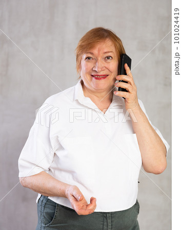 Senior woman taking phone call confidently with smile full of cheer Senior woman taking phone call confidently with smile full of cheer 101024419