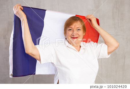 Cheerful senior woman standing confidently with french flag 101024420