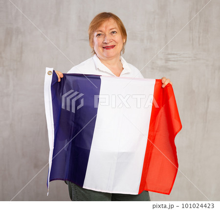 Cheerful senior woman standing confidently with french flag 101024423