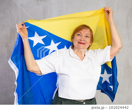 Cheerful senior woman standing confidently with bosnian flag 101024442