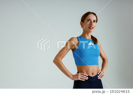 Athletic strong woman wearing sportswear standing on studio background. Healthy life concept 101024633