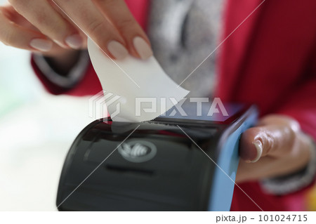Female cashier tears out check form POS terminal in store 101024715