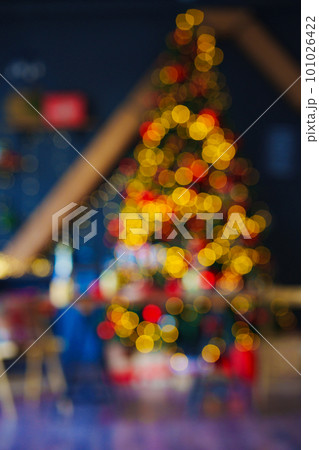 unfocused. a large Christmas tree decorated in a room with a black wall. blur unfocused. a large Christmas tree decorated in a room with a black wall. blur 101026422
