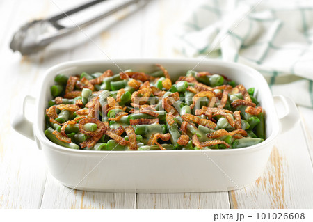 Green bean casserole sprinkled with crispy fried onions served on ceramic cooking baking dish.  Healthy summer veggie food. 101026608