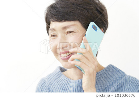 笑顔でスマホで電話する中年女性 白背景 笑顔でスマホで電話する中年女性 白背景 101030576