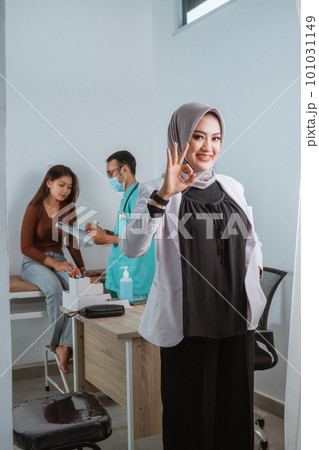 a beautiful doctor standing with oke gesture and smilling 101031149