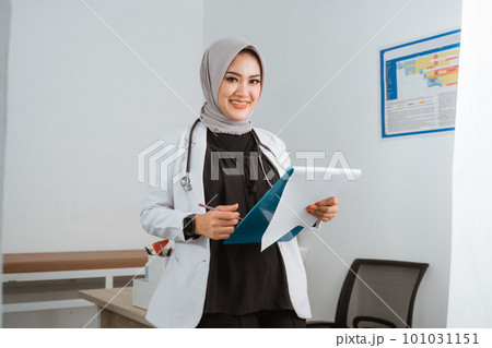 a female doctor standing lean on the doctor's table 101031151
