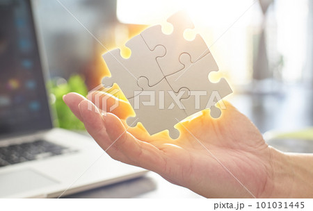 Close Up hand held jigsaw puzzle with sunlight affect 101031445
