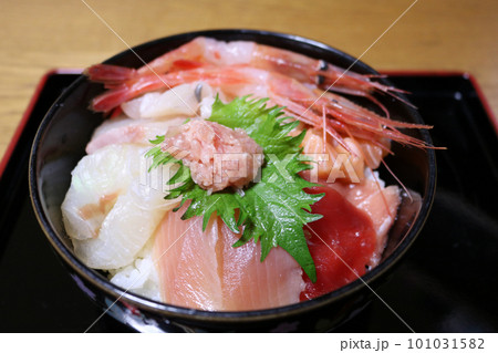 黒の塗り盆にのった新鮮な魚介類たっぷりの海鮮丼 黒の塗り盆にのった新鮮な魚介類たっぷりの海鮮丼 101031582