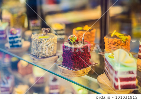Different types of cakes in pastry shop glass display 101031915