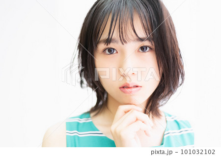 窓際に立って、こちらを見つめている若い女性 101032102