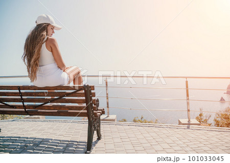 Woman summer travel sea. Happy tourist enjoy taking picture outdoors for memories. Woman traveler posing over sea bay surrounded by volcanic mountains, sharing travel adventure journey Woman summer travel sea. Happy tourist enjoy taking picture outdoors for memories. Woman traveler posing over sea bay surrounded by volcanic mountains, sharing travel adventure journey 101033045