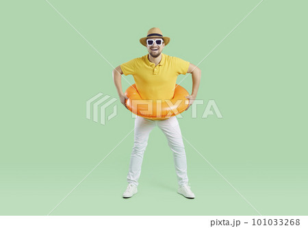 Happy funny young guy having fun with inflatable ring and enjoying his summer holiday Happy funny young guy having fun with inflatable ring and enjoying his summer holiday 101033268