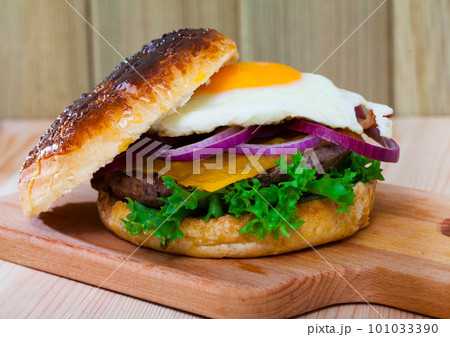 Hamburger with with fried egg, beef, onion, cheese and lettuce Hamburger with with fried egg, beef, onion, cheese and lettuce 101033390