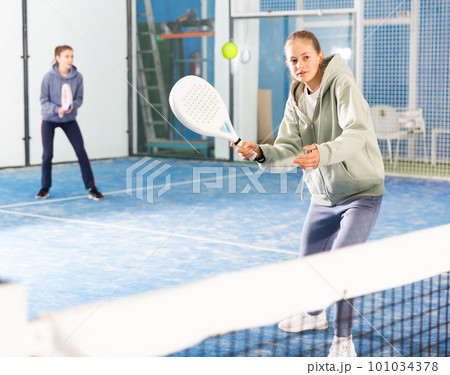 Young girl with racquet playing padel 101034378