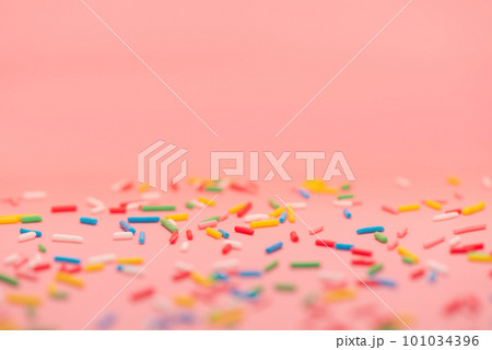 colorful sprinkles over pink background copy space 101034396