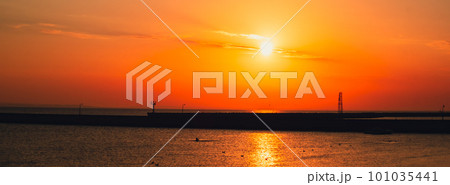 Reflection of sunlight over sea surface at sunset. Orange and gold blue sky. Dramatic Yellow sun coming out of the sea. Majestic summer landscape 101035441