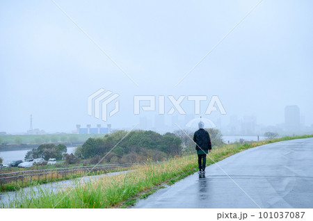 雨の日に土手を歩く人 雨の日に土手を歩く人 101037087