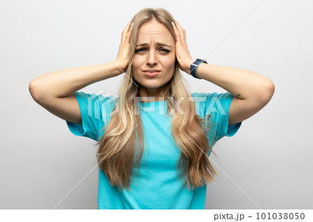 girl holding on to a sore head on a white background 101038050