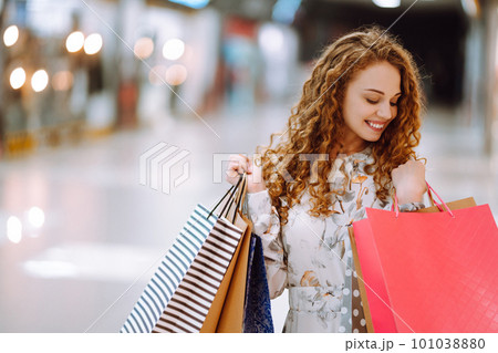 Fashionable woman with multi-colored bags in modern shop center. The joy of consumption. Fashionable woman with multi-colored bags in modern shop center. The joy of consumption. 101038880