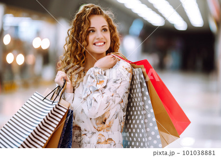 Fashionable woman with multi-colored bags in modern shop center. The joy of consumption. Fashionable woman with multi-colored bags in modern shop center. The joy of consumption. 101038881