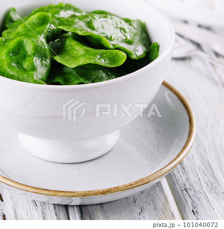 Tasty green dumplings on white bowl Tasty green dumplings on white bowl 101040072