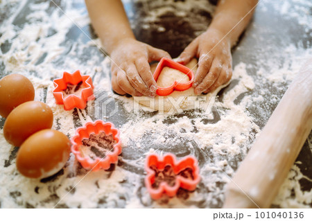 Kids hands cutting out shapes and making cookies. Children's art project, a craft for children. Kids hands cutting out shapes and making cookies. Children's art project, a craft for children. 101040136