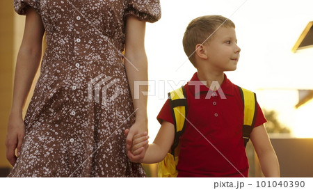 mother holds hand child school backpack glare sunlight. happy family concept. mother child go lesson school class. child boy go school early morning. sunlight. parent child first school bag lesson mother holds hand child school backpack glare sunlight. happy family concept. mother child go lesson school class. child boy go school early morning. sunlight. parent child first school bag lesson 101040390