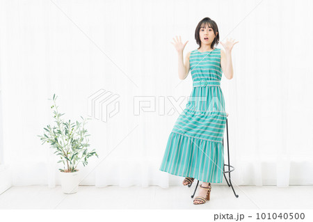 椅子に座って驚いたポーズをする若い女性 椅子に座って驚いたポーズをする若い女性 101040500