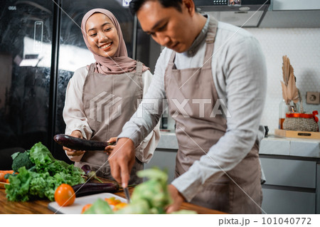 husband and wife enjoy cooking food together in the kitchen 101040772