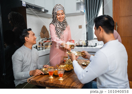 husband and wife serving food for friend for break fasting 101040858