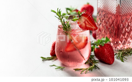 Gin and tonic cocktail with natural ice, strawberries, and rosemary. Gin and tonic cocktail with natural ice, strawberries, and rosemary. 101041093