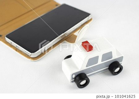 スマートフォンと玩具のパトカー。通報するイメージ 101041625
