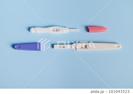 Top view inkjet pregnancy tests with taking place biochemical reaction between female urine and chorionic human gonadotropin hormone, appearing in two bars, over blue background. Finally pregnant 101043523