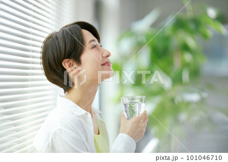 水の入ったグラスを持つ笑顔のミドル女性 水の入ったグラスを持つ笑顔のミドル女性 101046710