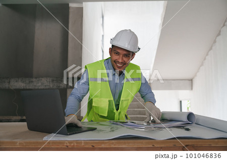 Architect or Engineer working with blueprints for architectural plan, engineer sketching a construction project, green energy concept Architect or Engineer working with blueprints for architectural plan, engineer sketching a construction project, green energy concept 101046836