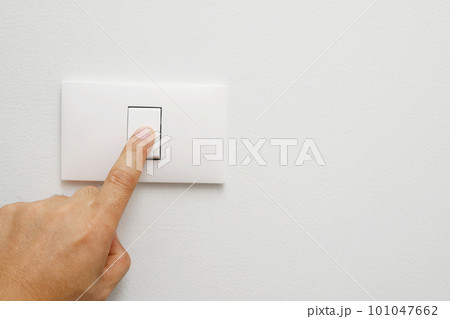 Turn off the light, close up female hand is closing the power switch. Save energy, reduce global warming.. 101047662
