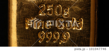 Stamped writing on a cast gold bar, also known as gold bullion. Refined metallic gold, produced by by pouring molten metal into a bar-shaped mold. 250 gram fine gold, equal to 8.04 troy ounces. Photo. Stamped writing on a cast gold bar, also known as gold bullion. Refined metallic gold, produced by by pouring molten metal into a bar-shaped mold. 250 gram fine gold, equal to 8.04 troy ounces. Photo. 101047746