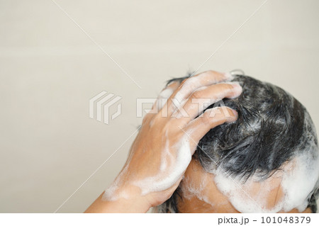 A man is washing his hair with shampoo. A man is washing his hair with shampoo. 101048379