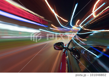Long exposure of a speedy night drive in a big city 101048802