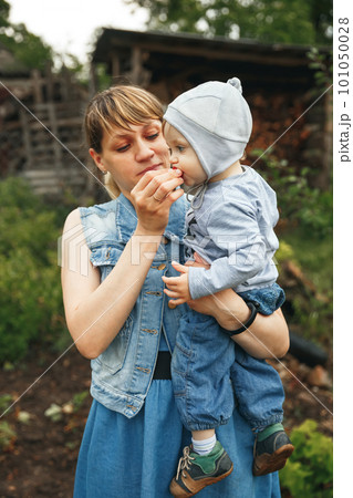 Mother giving son strawberries to taste. Beautiful mother feeding her baby boy. 101050028